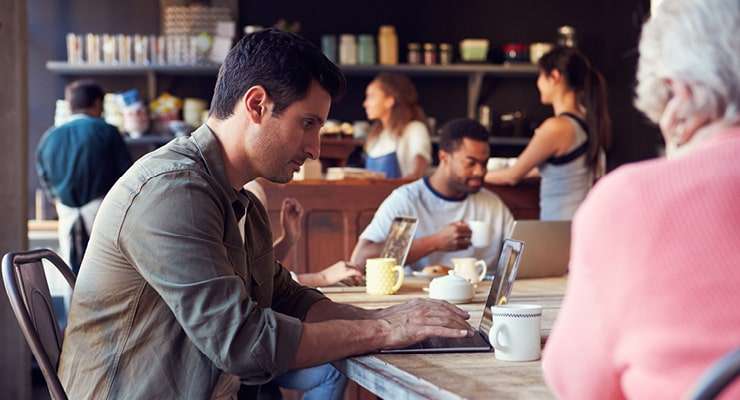 man working on his computer at a cafe