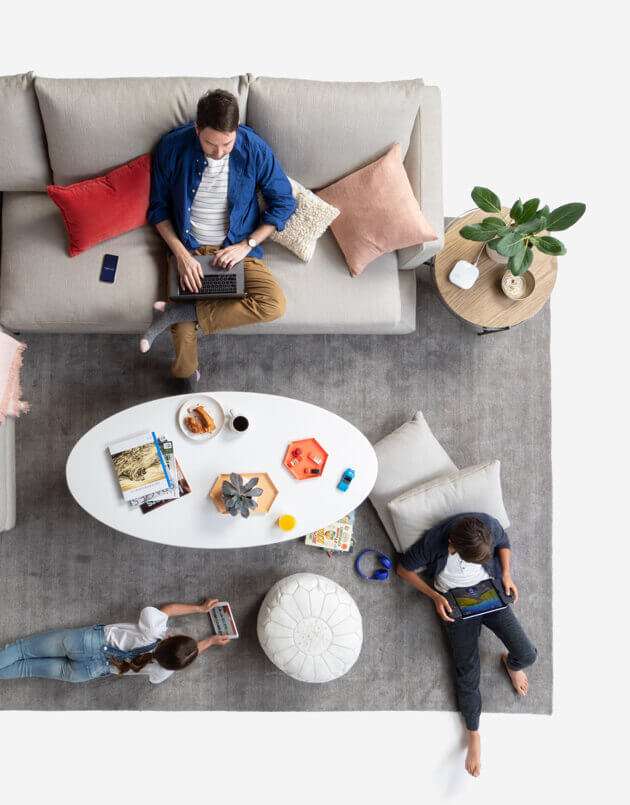 top view of a family on their devices scattered around their living room