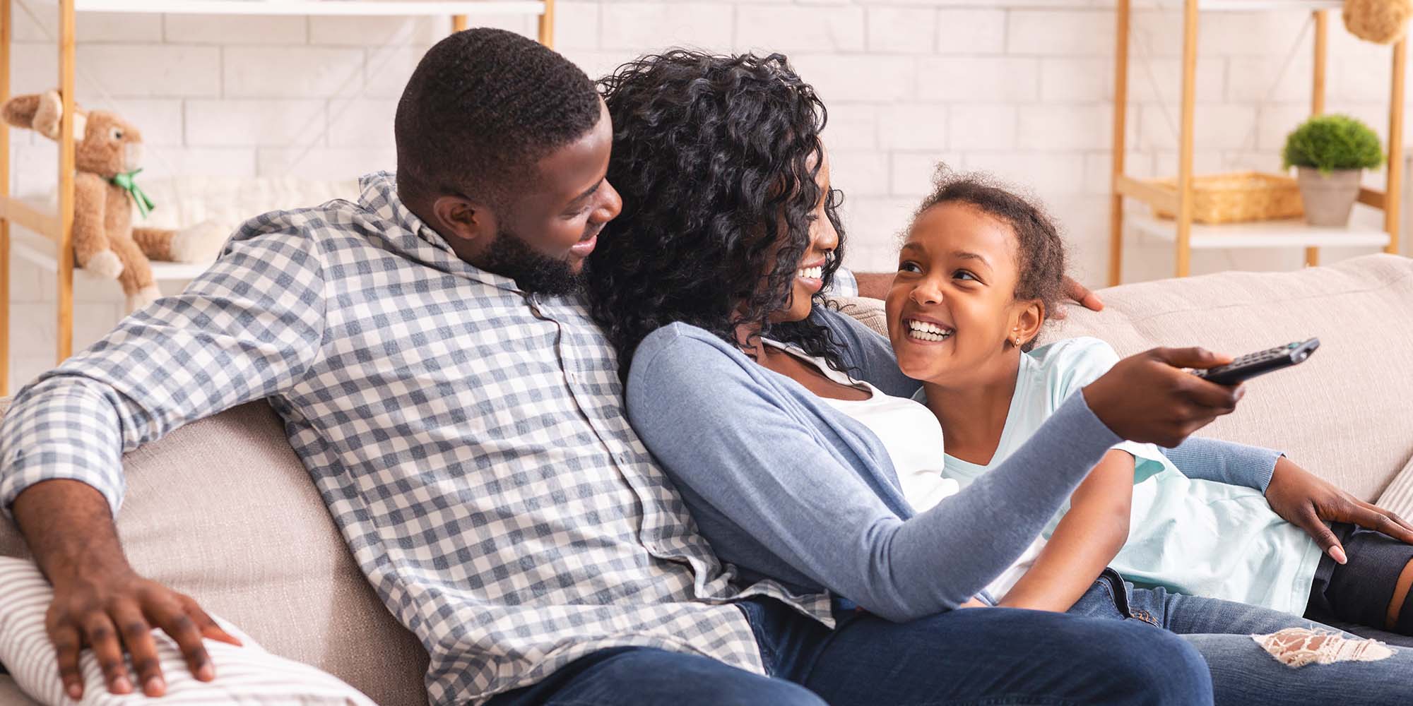 a family on a couch changing the channel