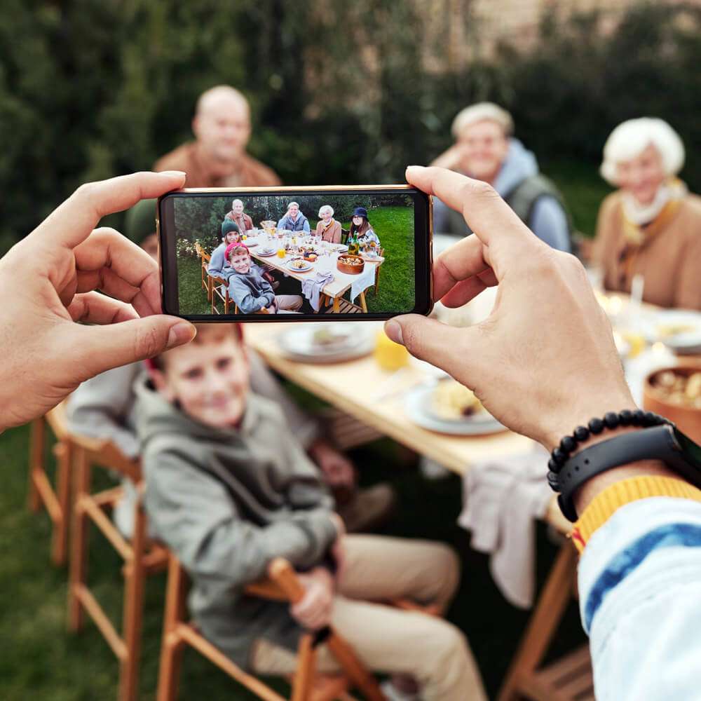 person taking photo of their family on their phone