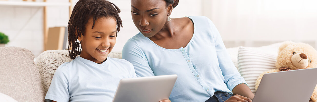 mother looking over at their child's screen