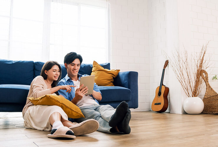 Couple sitting on the floor of their new home sets up Whole Home WiFi