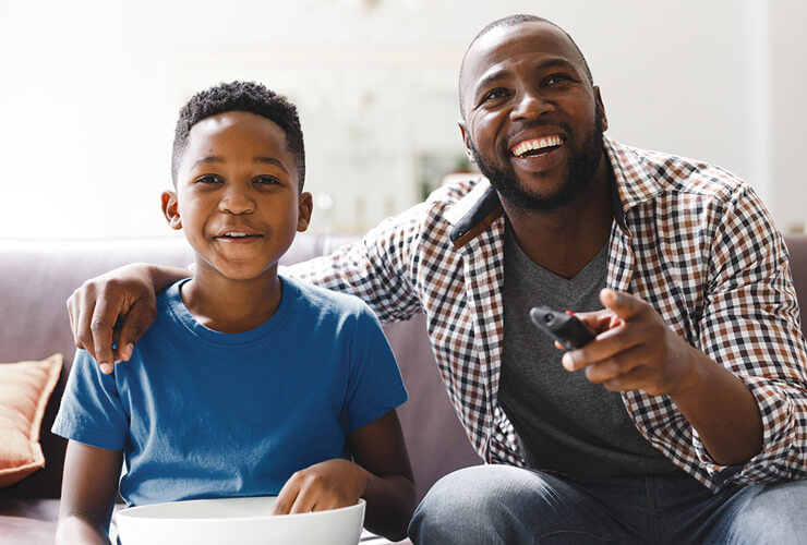 Dad and son watching favorite shows together on Father's Day